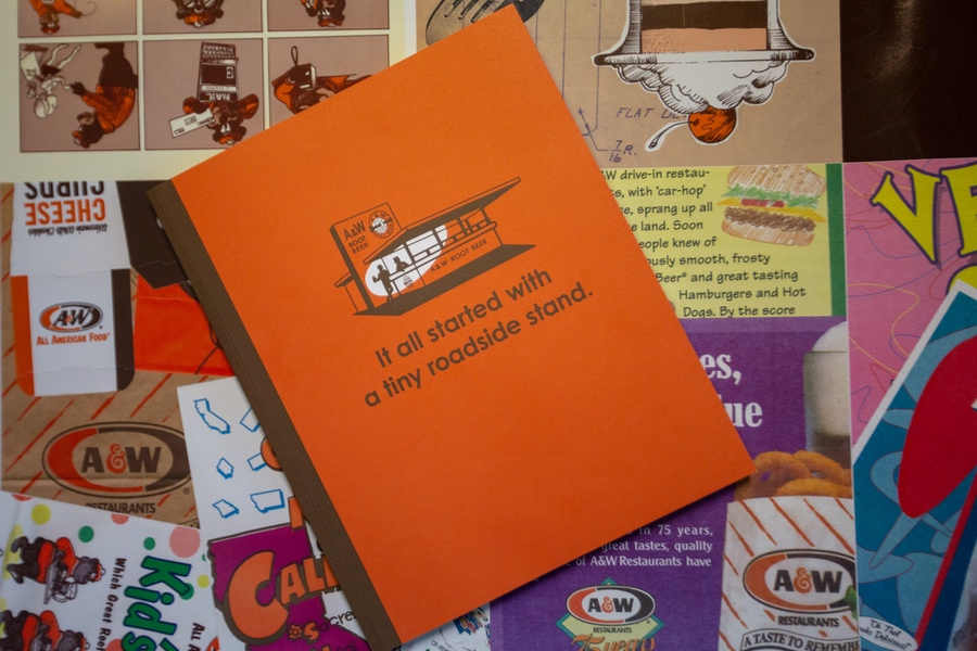 A&amp;amp;W Restaurants 100th Anniversary Book overhead view on vintage A&amp;amp;W ad background.