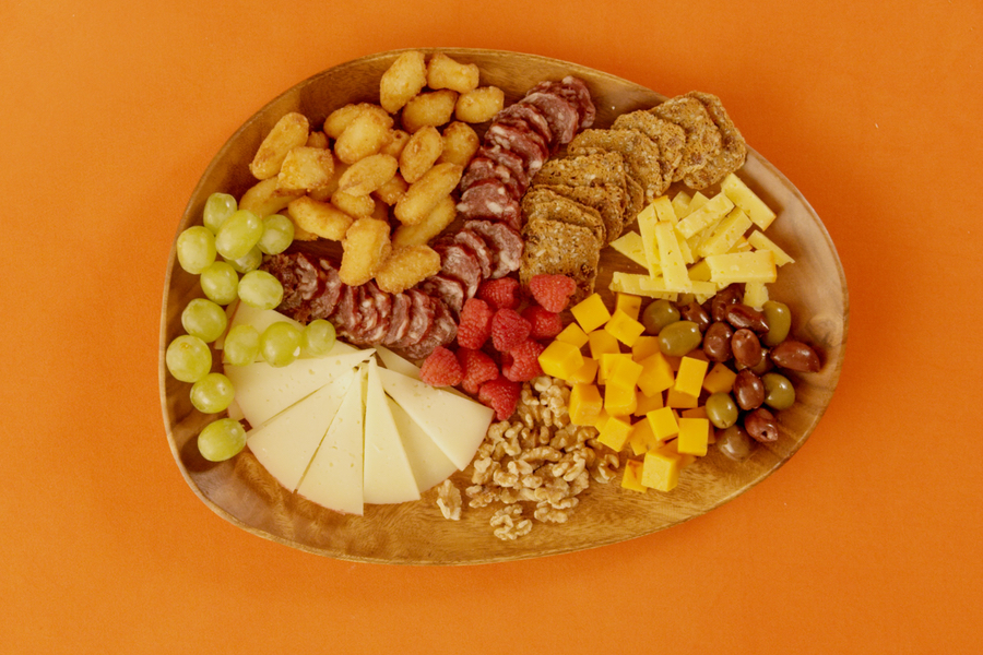 Overhead photo of the Movie Night Char-curd-erie Board on an orange background.